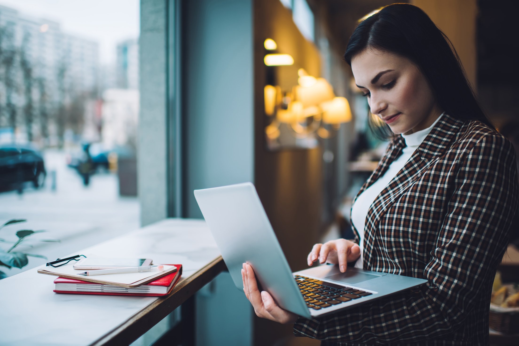 Lady remote worker using laptop in cafeteria